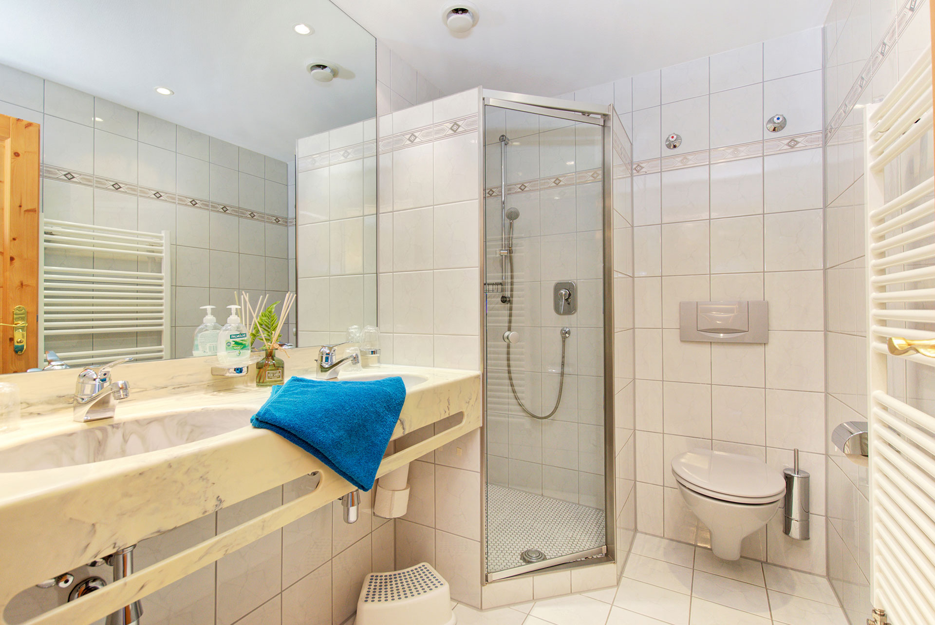 foto ferienwohnung badezimmer mit waschbecken und dusche sowie wc mit tuerkisfarbenem handtuch