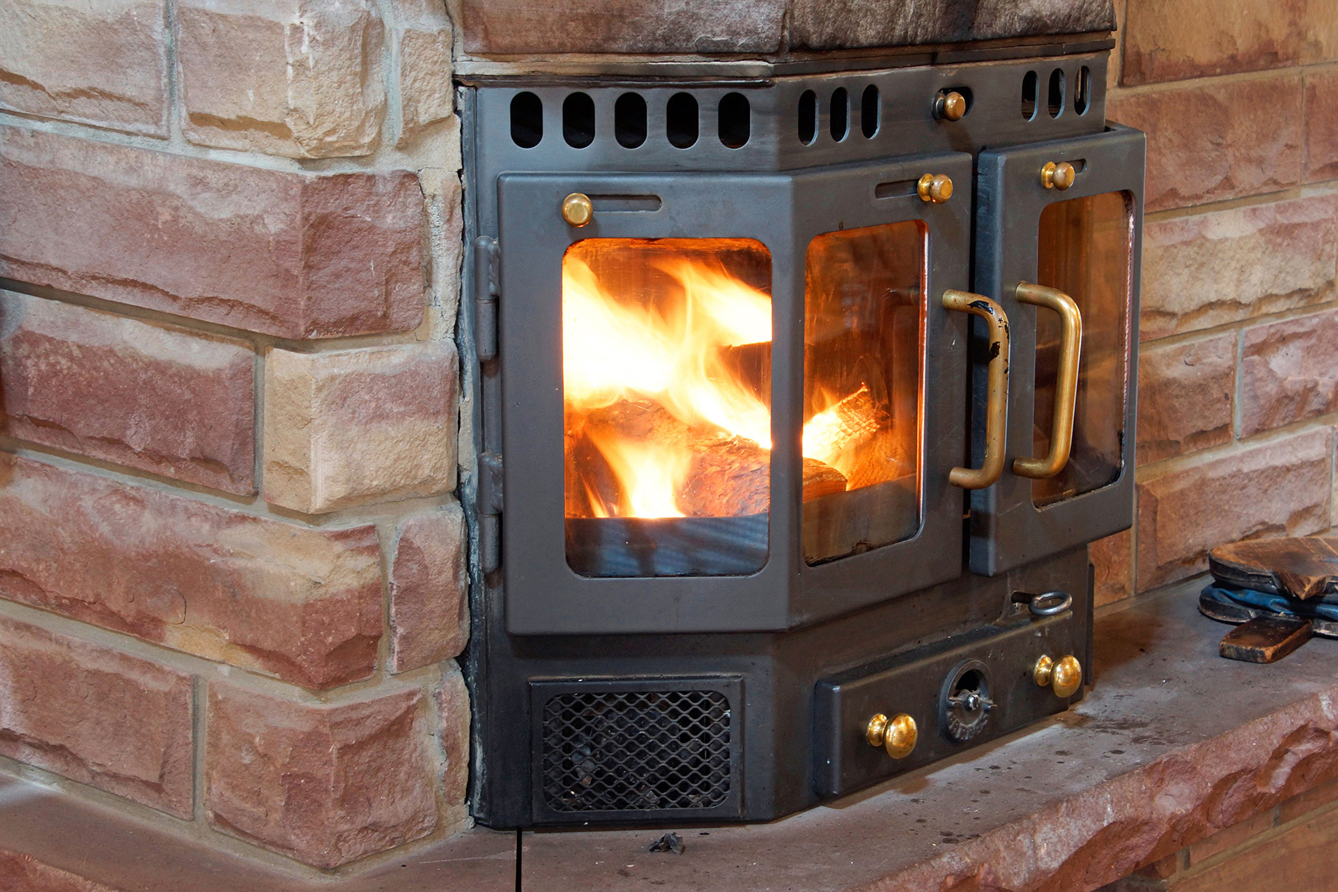 ferienhaus foto brennender gusseiserner kamin in sandsteine eingebaut