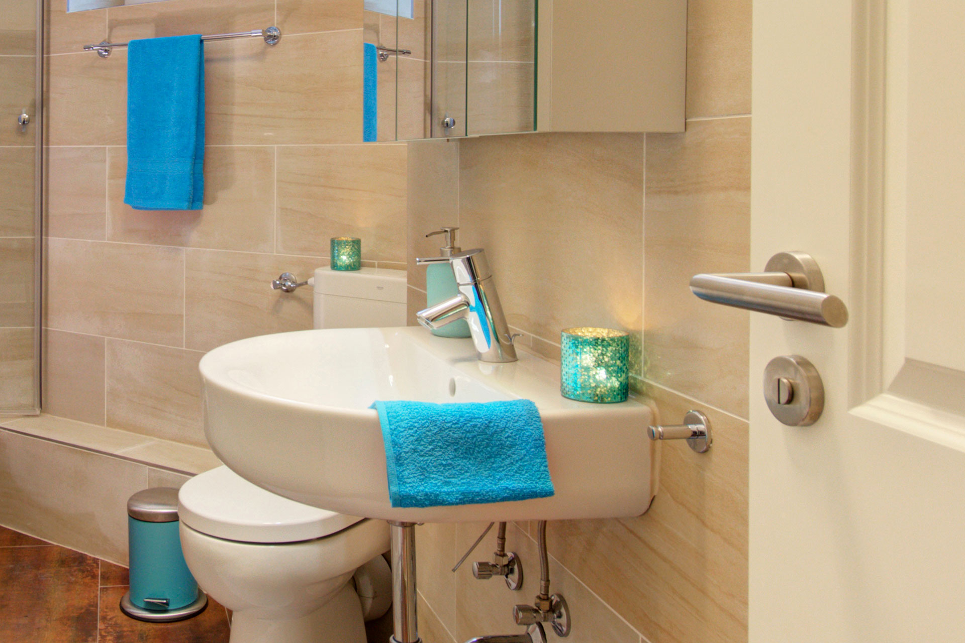 fotografin dekoriert waschbecken mit türkisem handtuch und teelicht