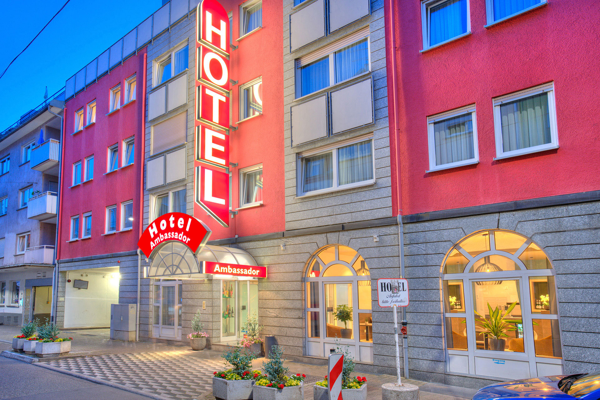 hotel abendaufnahme seitlich hotelschild leuchtet