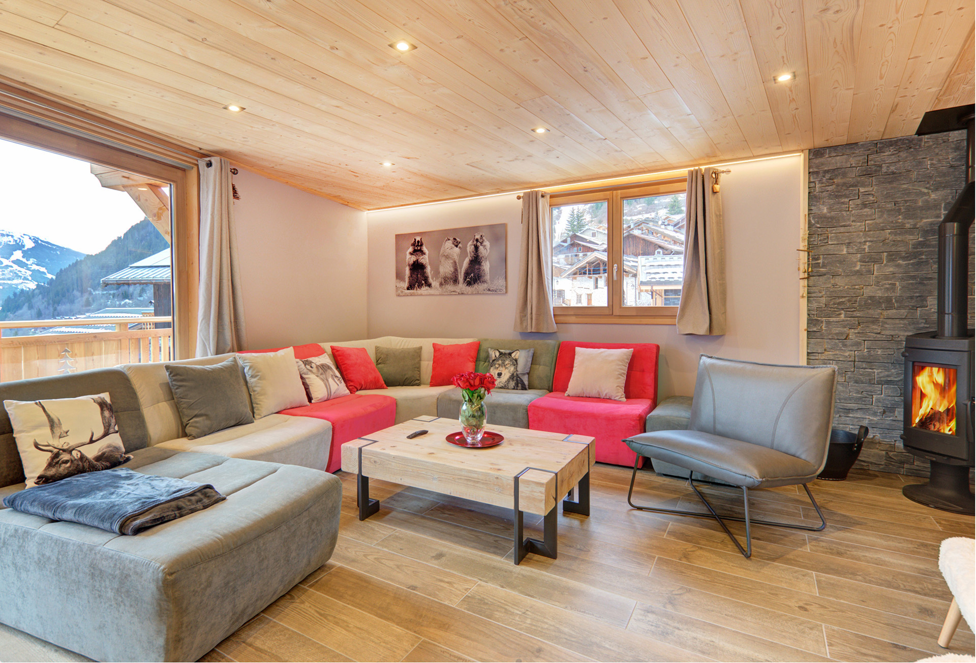 ferienhaus foto wohnraum mit sofalandschaft und brennendem kamin mit blick auf berpanoramafenster