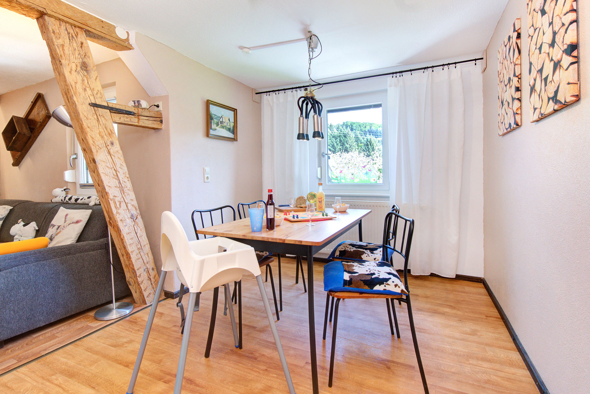 wohnzimmertisch mit vier stühlen und blick auf fensterFerienwohnung