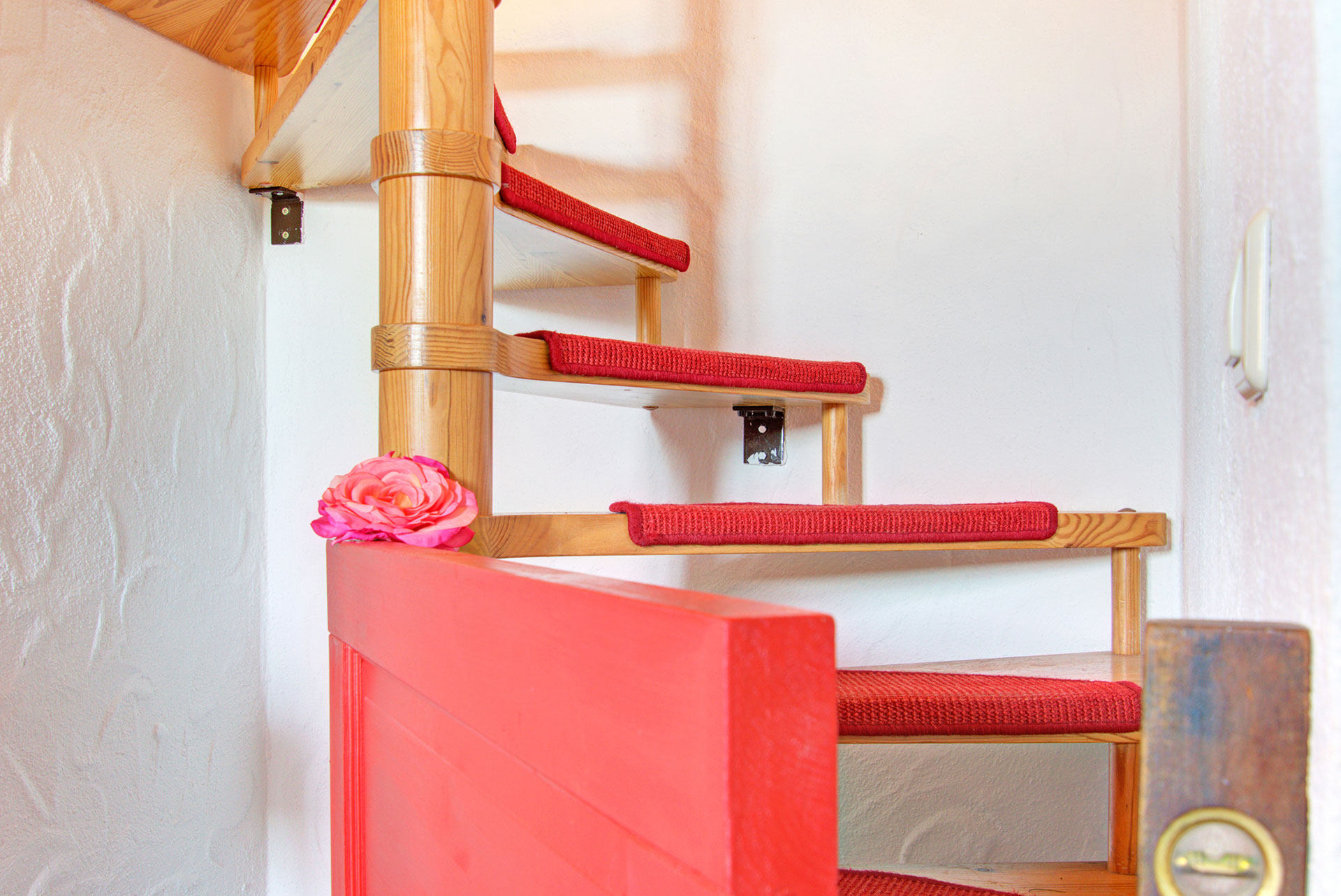 rote kindersicherung an wendeltreppe in ferienhaus