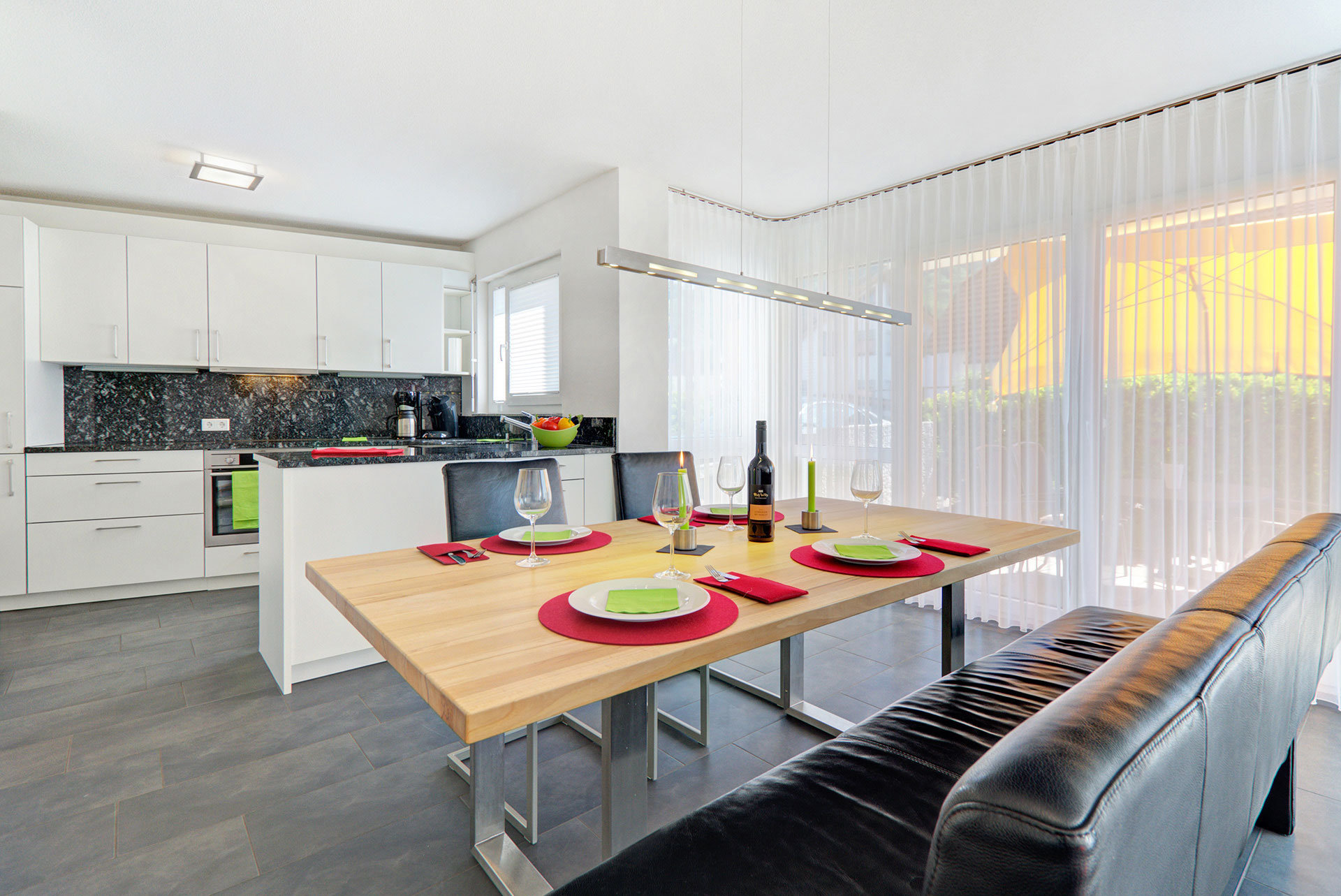 rot grün gedeckter tisch im hintergrund moderne küche in ferienwohnung