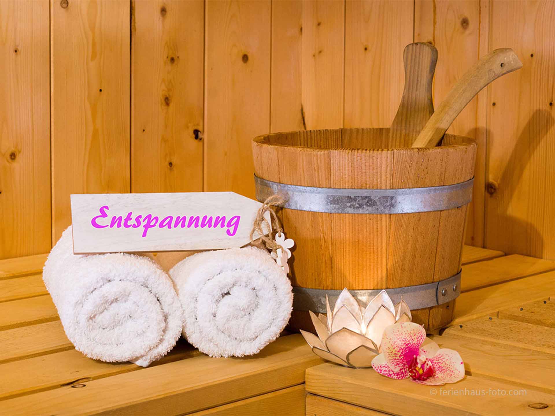 hotelfotograf schild in sauna beschriftet und handtücher und saunaeimer