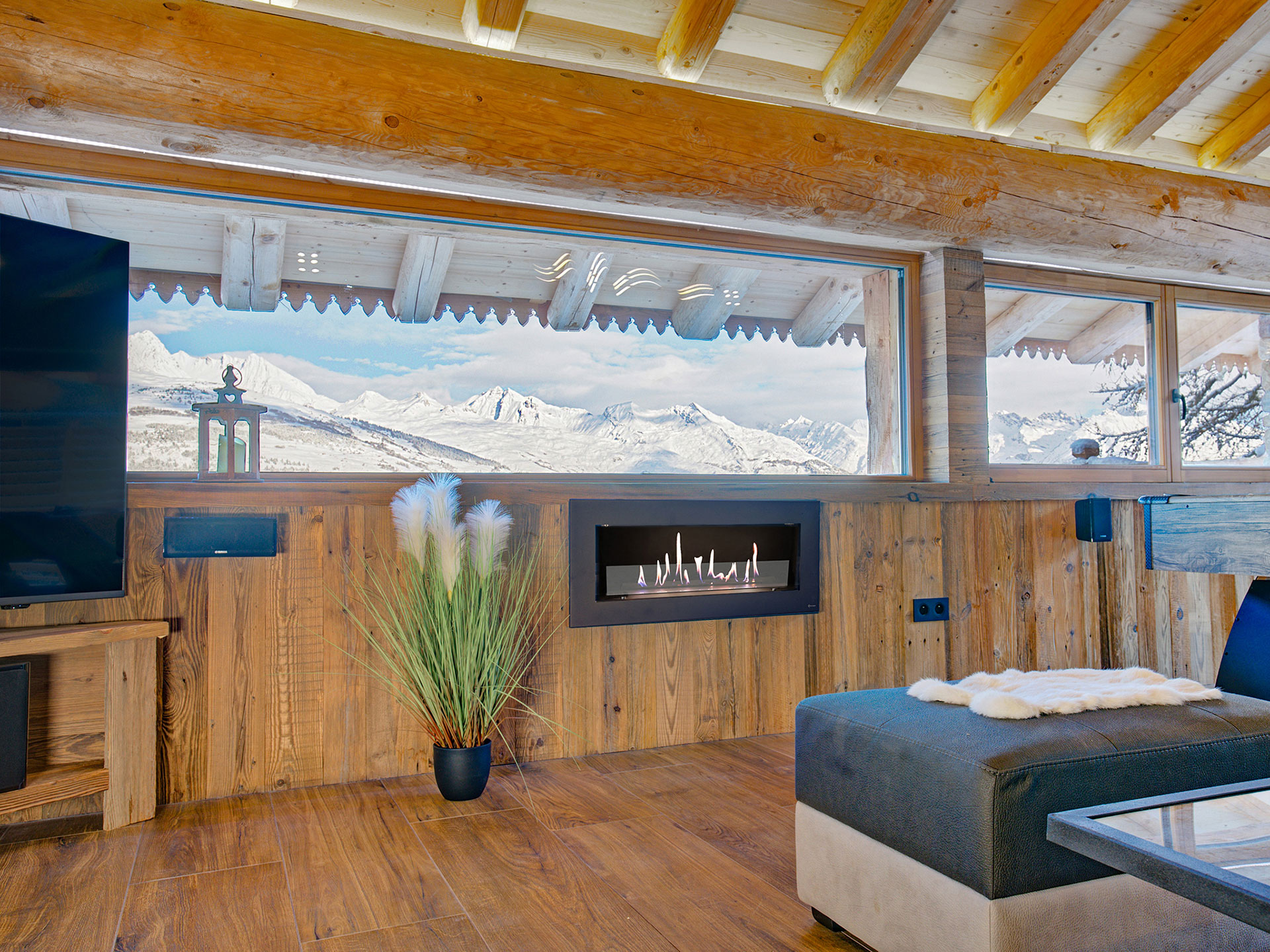 Wohnraum mit Blick auf Kamin und Schneeberge mit Mont Blanc