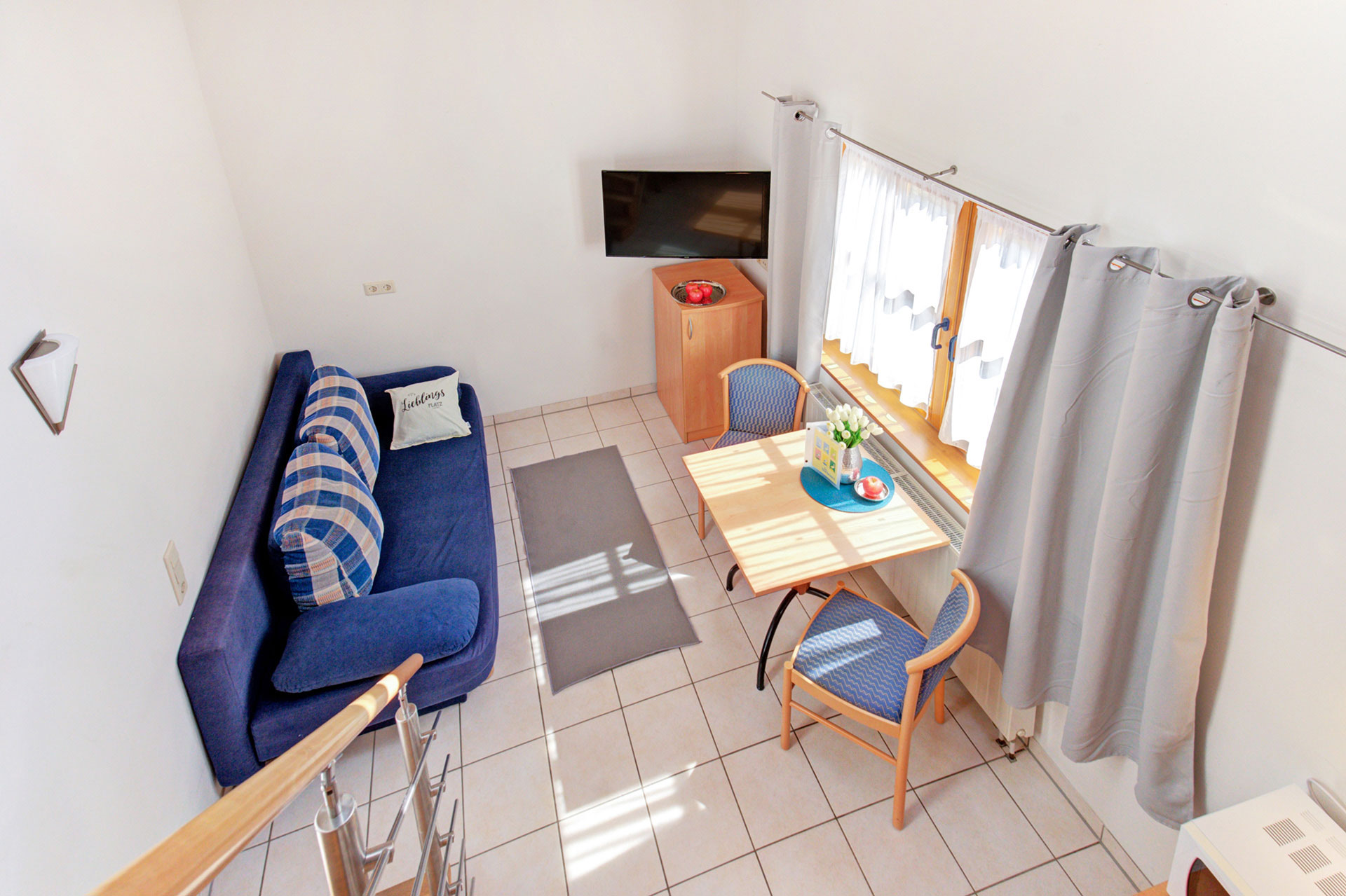 Wohnraum mit Esstisch und TV-gerät von Maisonette aus gesehen vom fotograf für ferienwohnungen