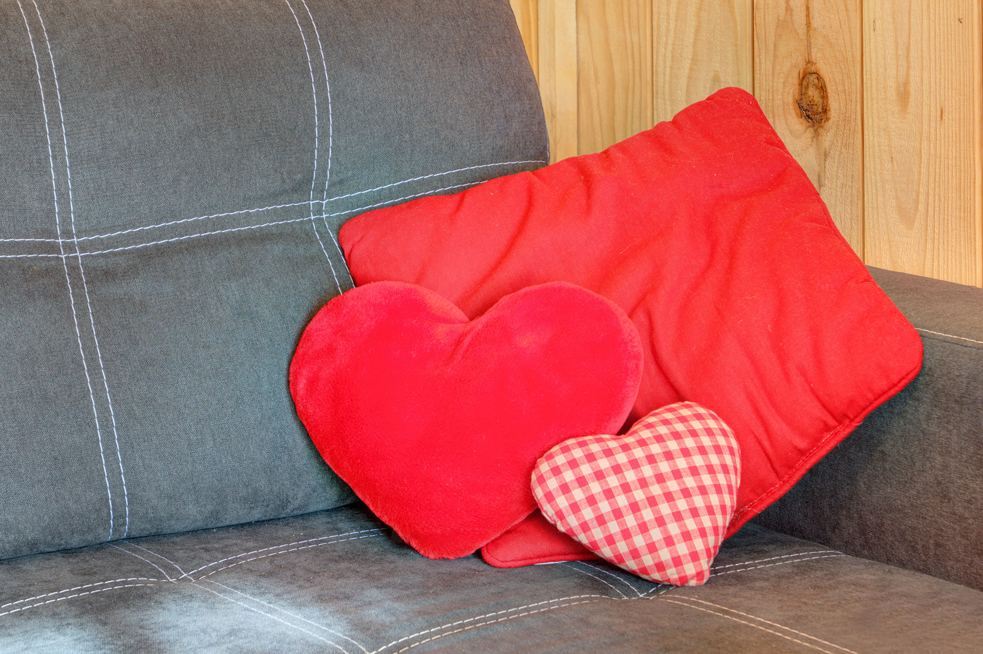 ferienhaus foto graues sofa mit roten kissen und kleinem karierten kissen