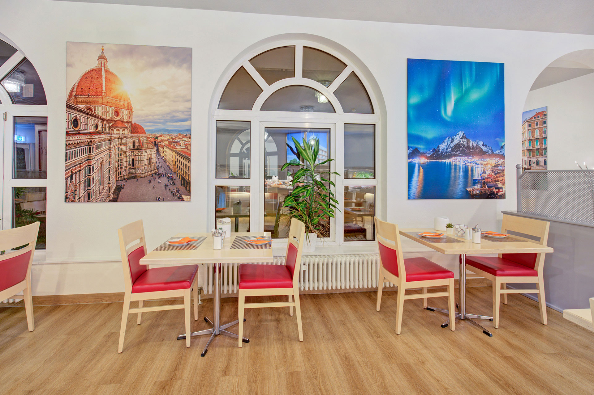zwei tische in hotel mit bildern von Rom und Polarlichter in Norwegen