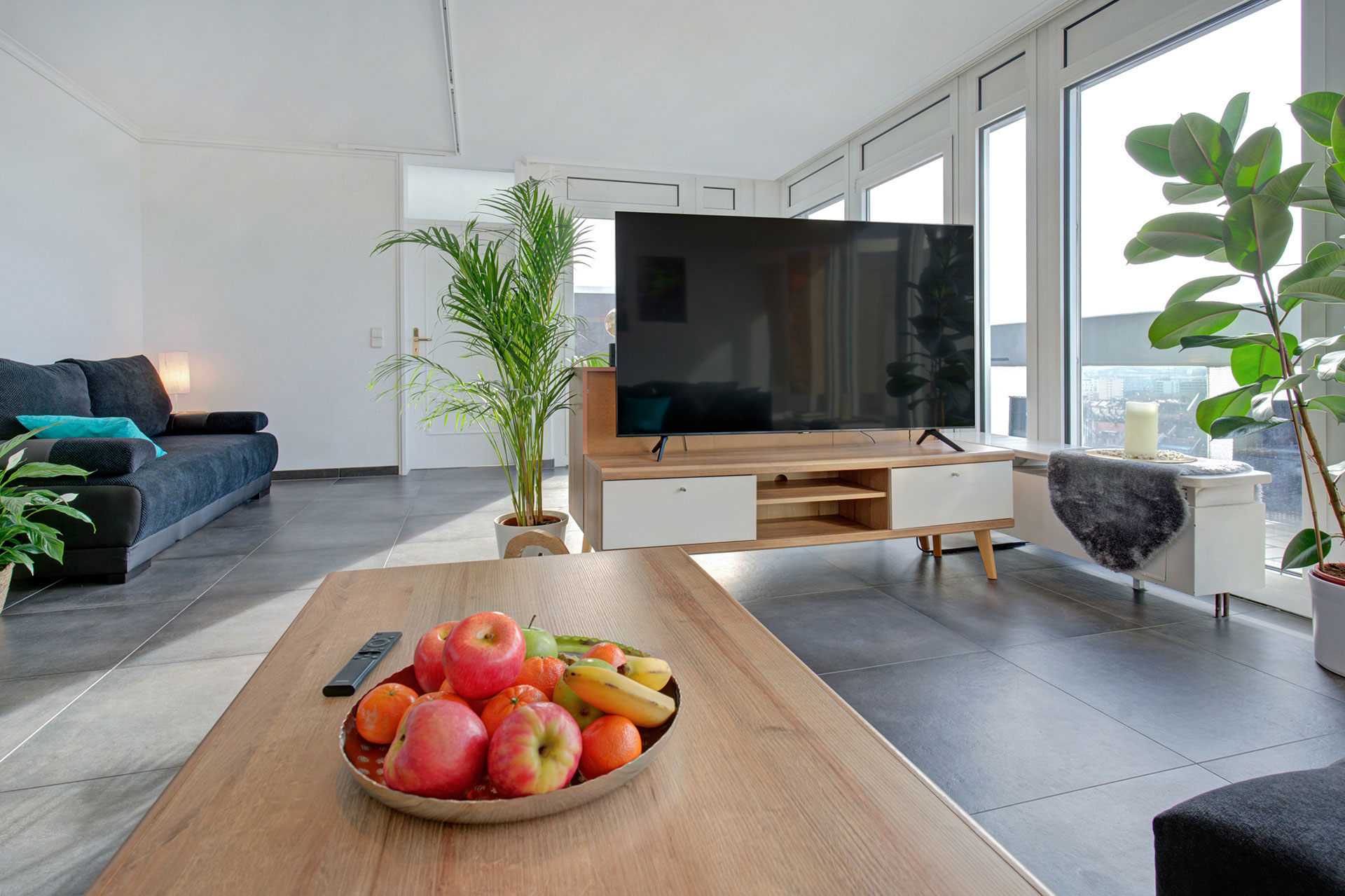 blick von sofa zu TV mit obstschale auf tisch in penthouse