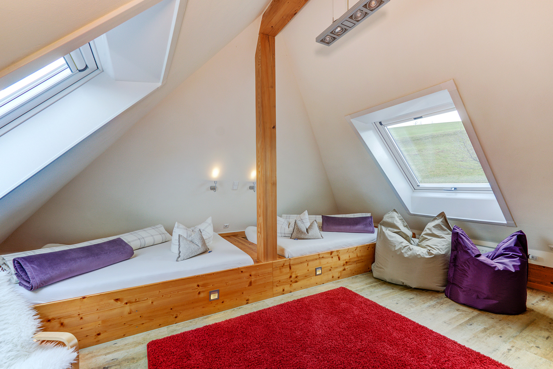ferienwohnung fotografieren zwei einzelbetten unter dachschräge und roter teppich