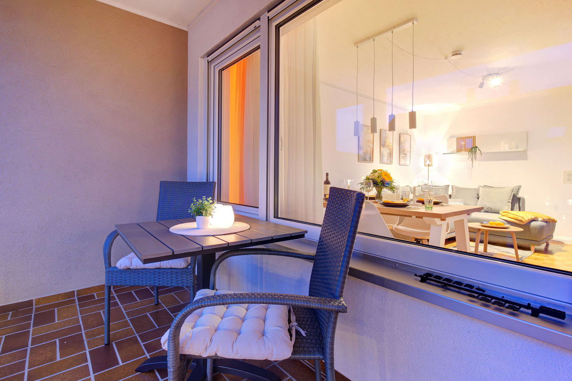 Balkon mit Sitzgruppe in Abendstimmung mit Blick in Wohnraum Fewo Stadtdomizil Waldshut