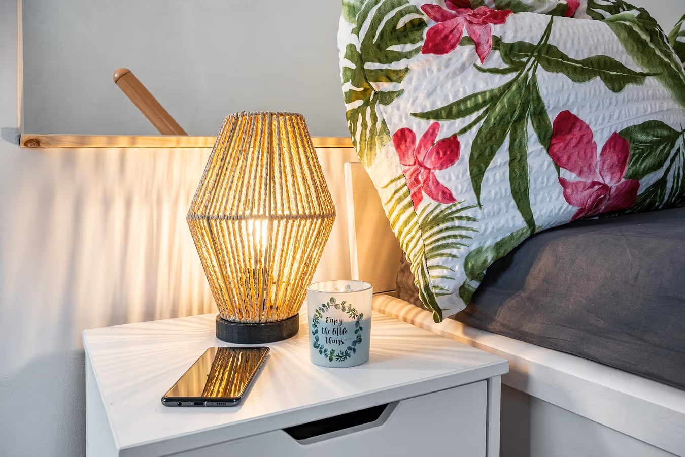 kreative komposition aus nachttisch mit teelicht und handy sowie Lampe - ferienwohnung fotografieren