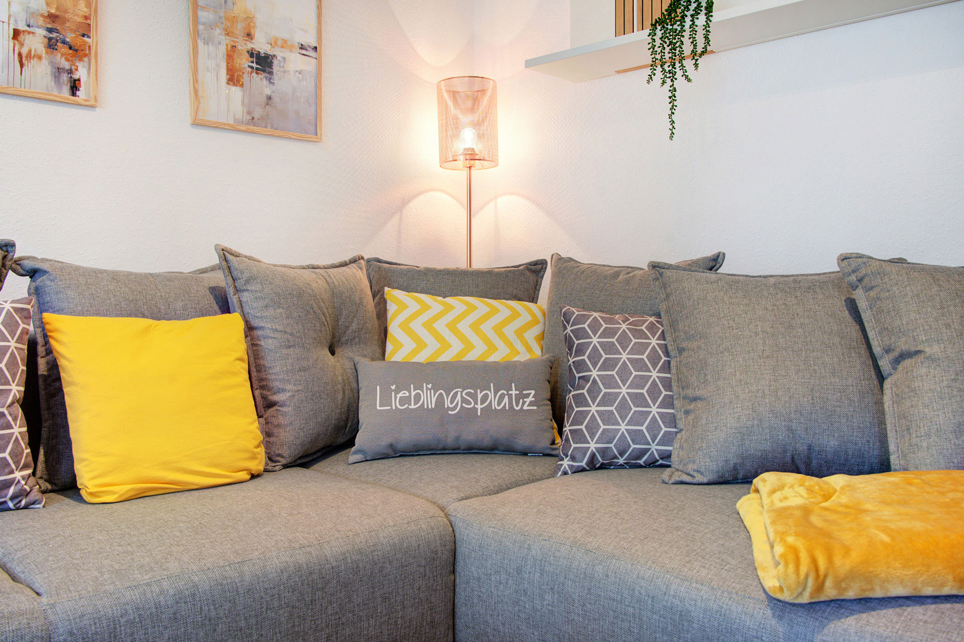 ferienwohnung fotografieren - Sofa in der ferienwohnung mit lieblingsplatzkissen sowie stehlampe