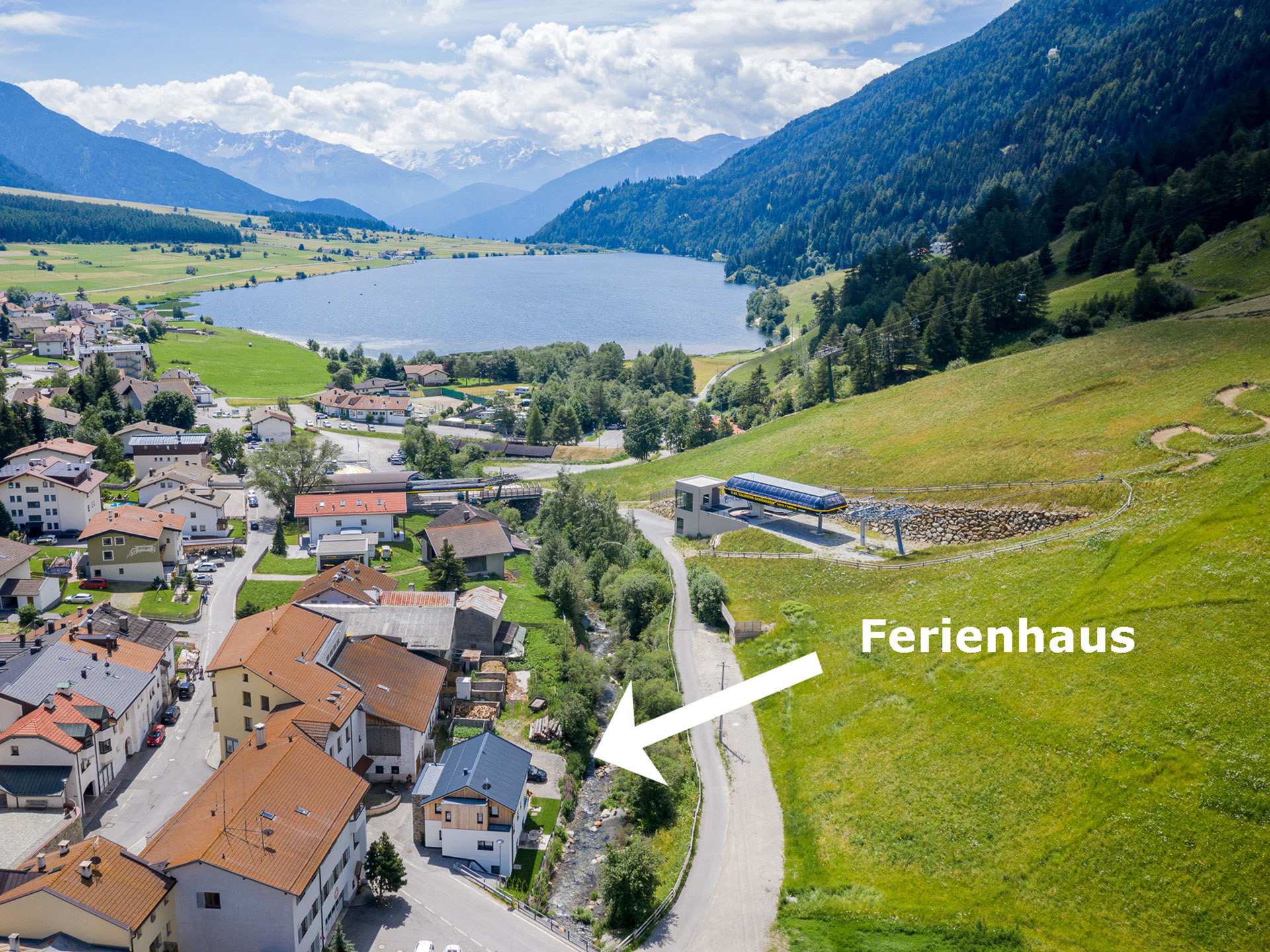Mit Pfeil markiertes modernes Chalet in Seenähe das mit einer Drohne aufgenommen wurde