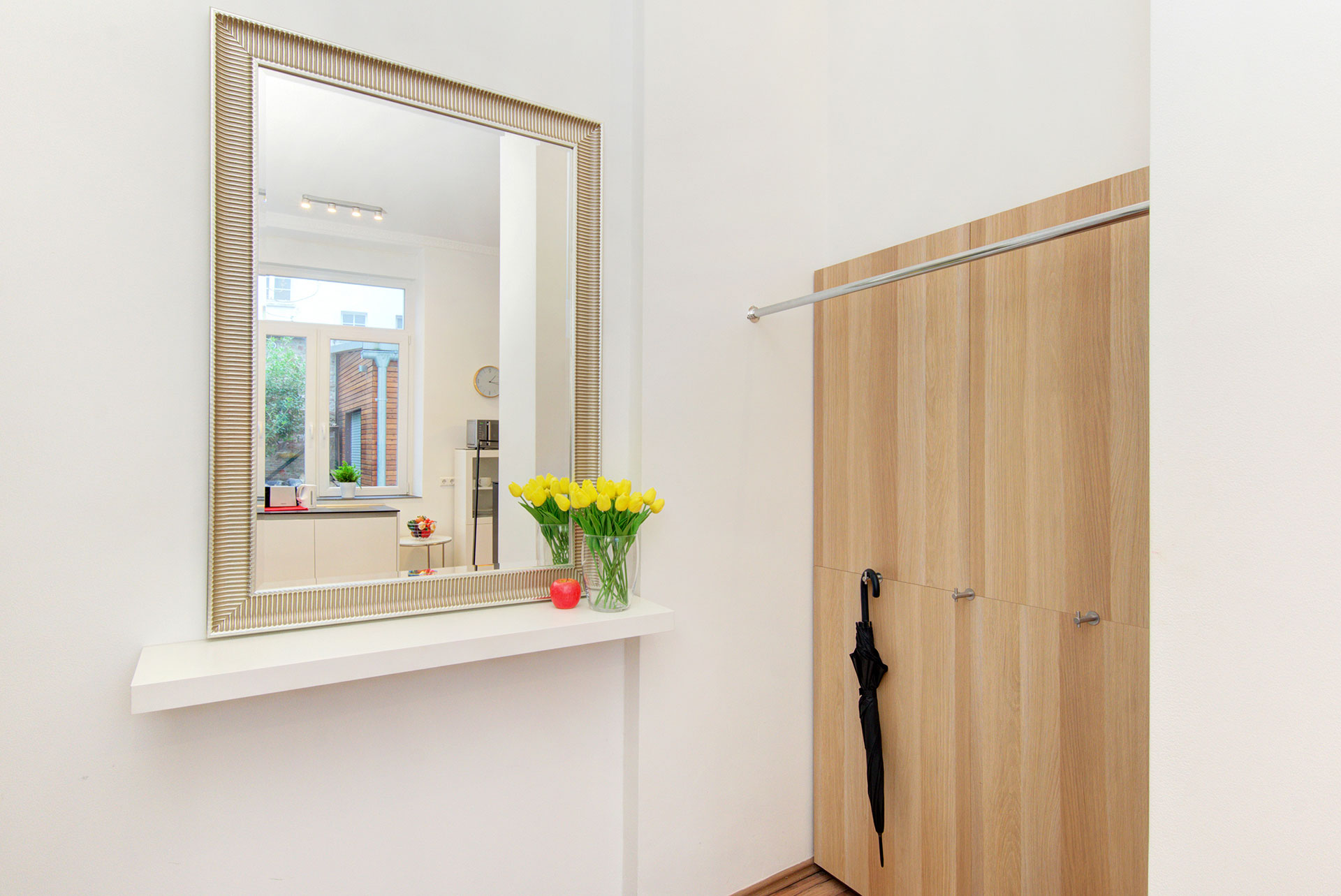 apartment fotografieren garderobe mit grossem spiegel und gelbem tulpenstrauss