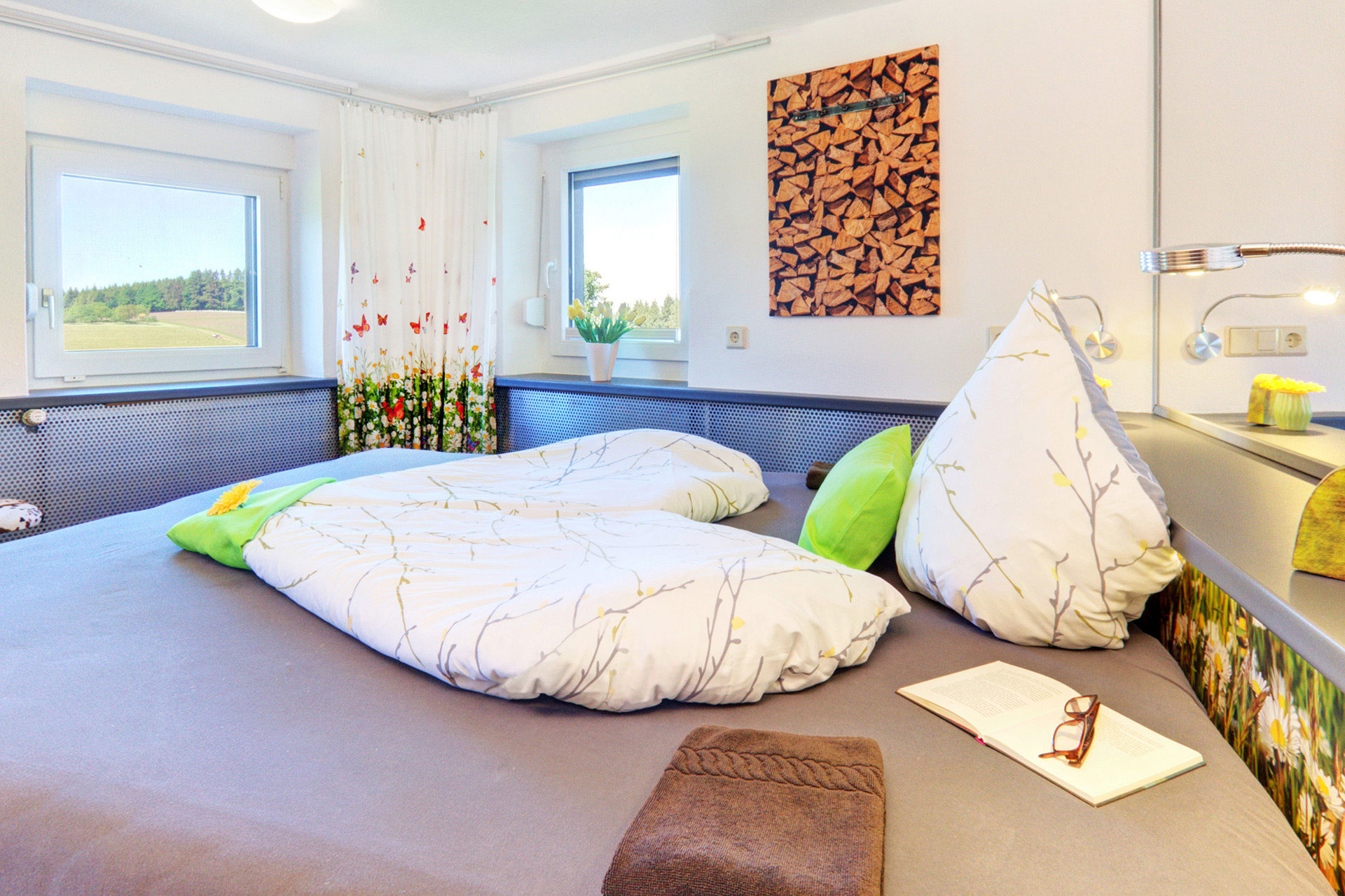doppelbett mit deckbett in herzform handtusch brille buch in ferienwohnung
