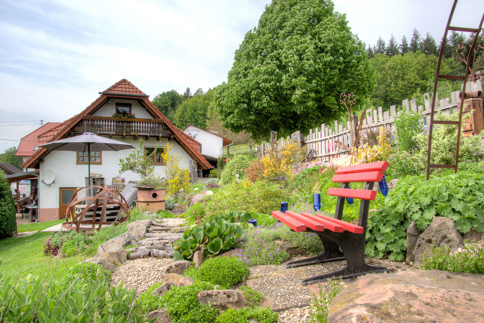 rote bank im barfusspark mit ferienhaus