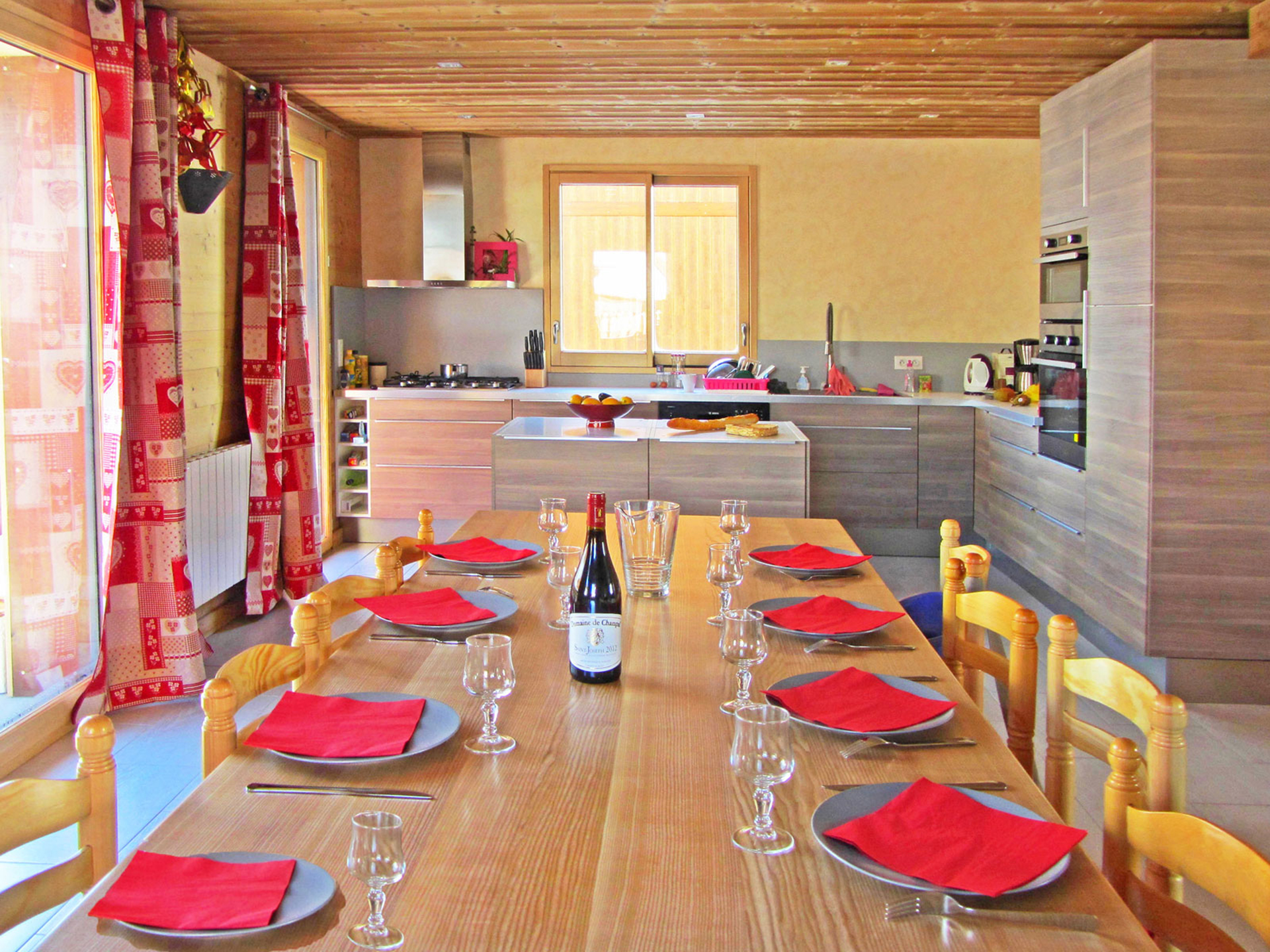 Ferienhaus-Esszimmer: roter Tisch, ein Gedeck hinzugefügt, gemütliche Atmosphäre - nachher