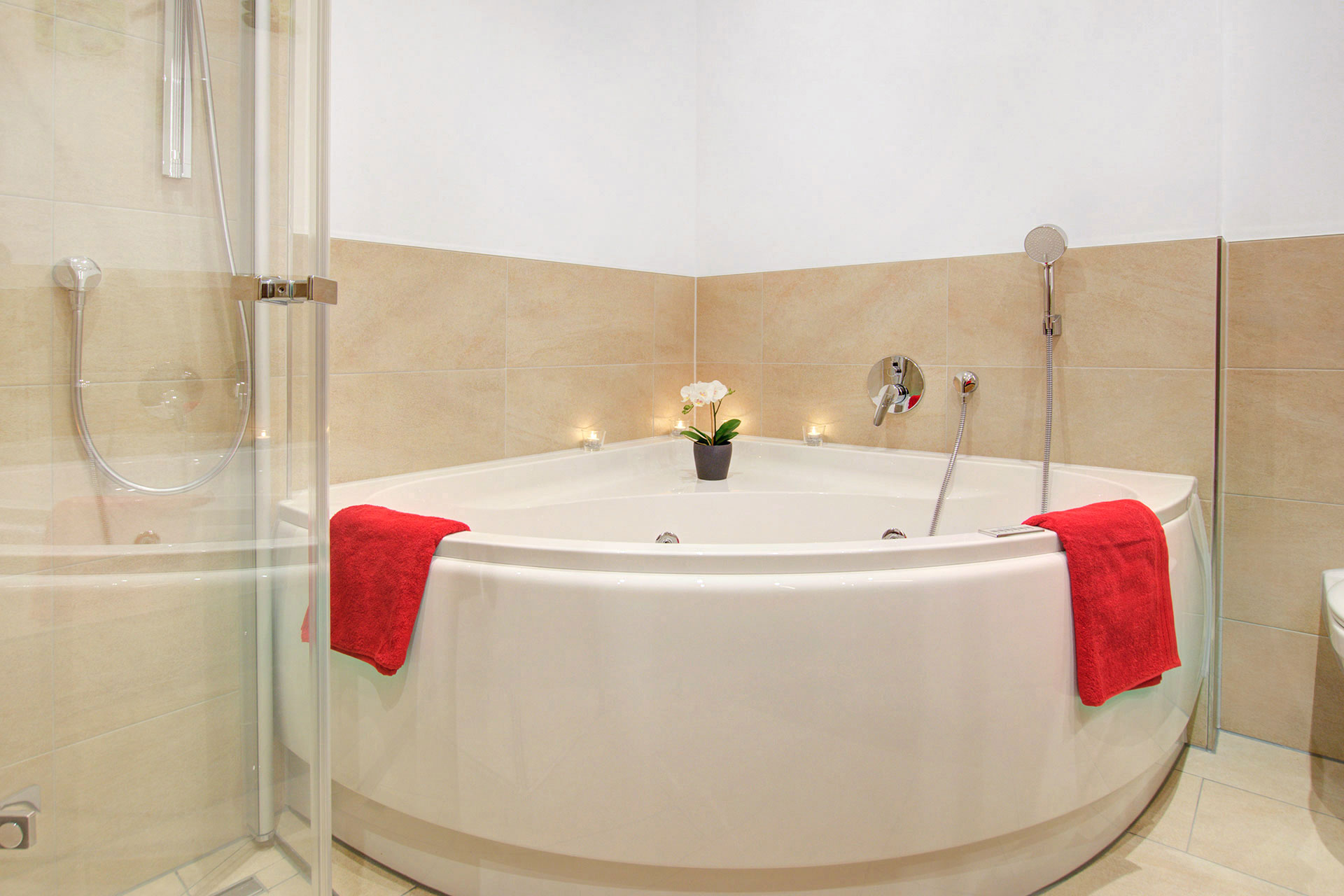 Whirlpoolbadewanne mit Teelichtern und roten Handtüchern in der Residenz Grafenmatt