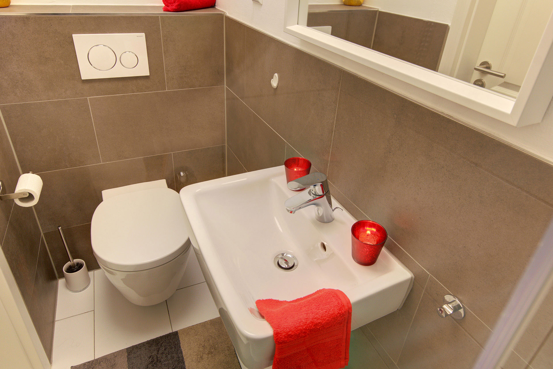 apartment fotografin waschbecken wc kleines rotes handtuch und rote teelichter