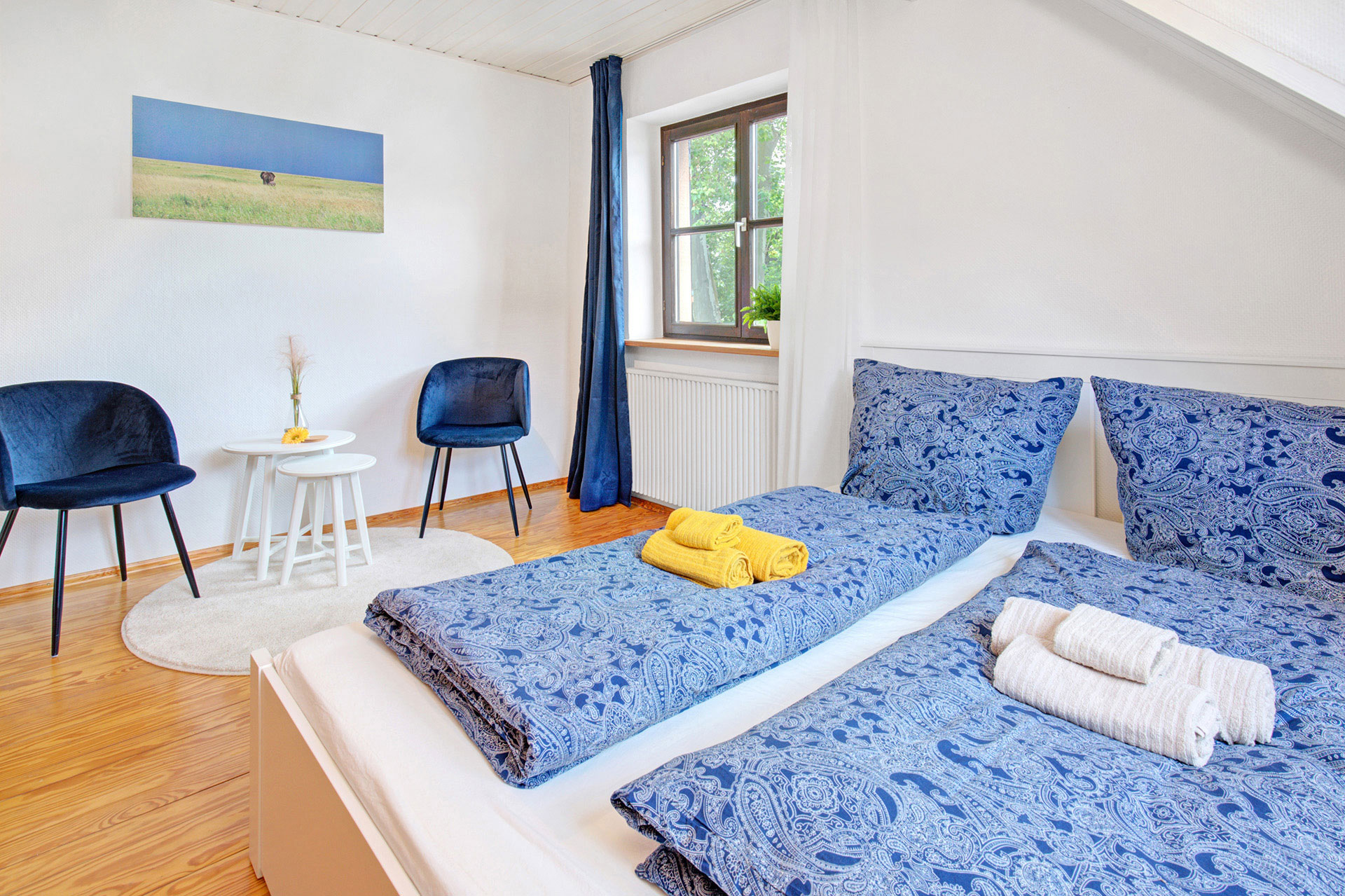 schlafzimmer mit sitzgruppe von blaue sitzgruppe von ferienhaus professionell fotografiert