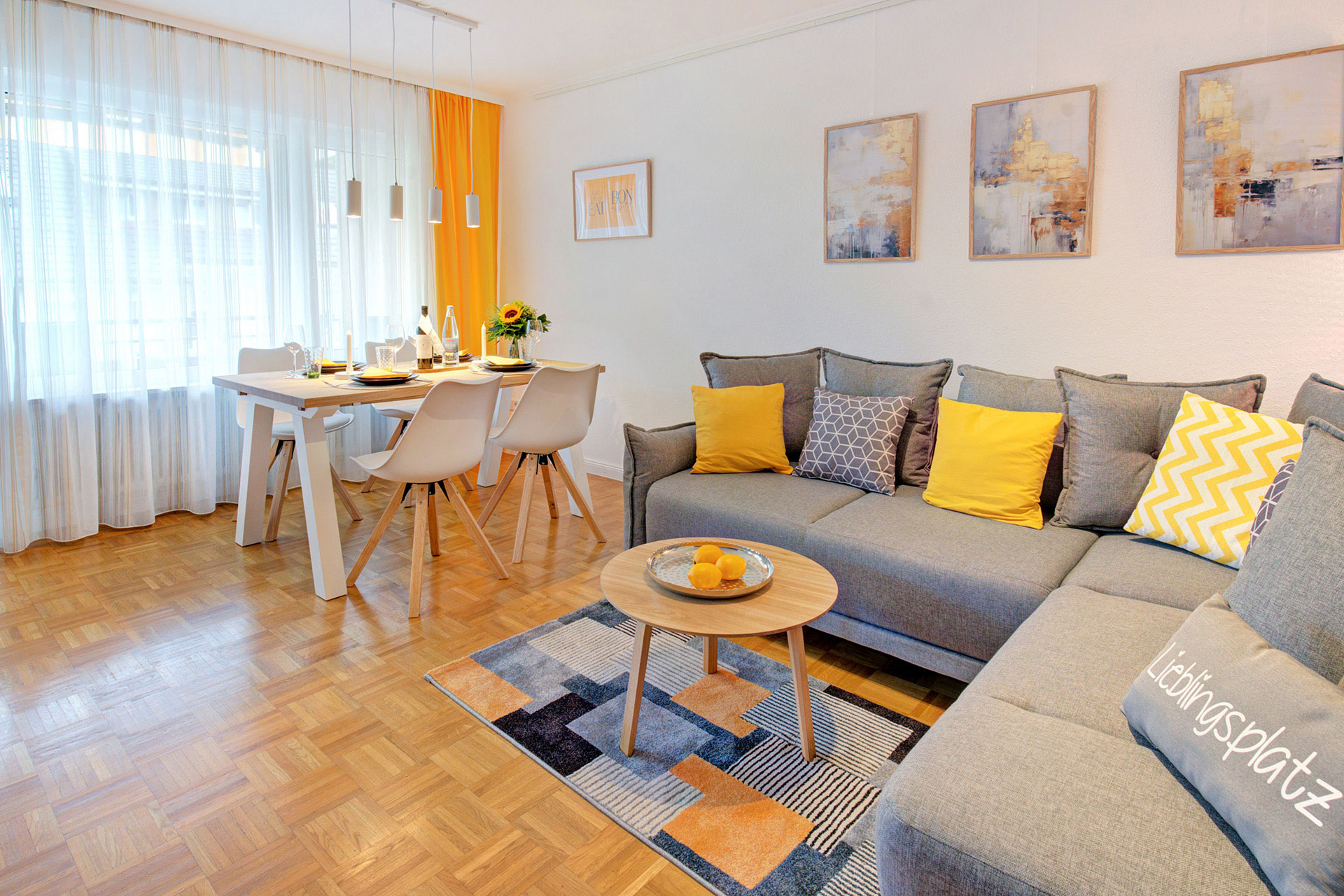 Wohnessbereich in ferienwohnung mit holzfussboden modernem esstisch und bequemen sofa