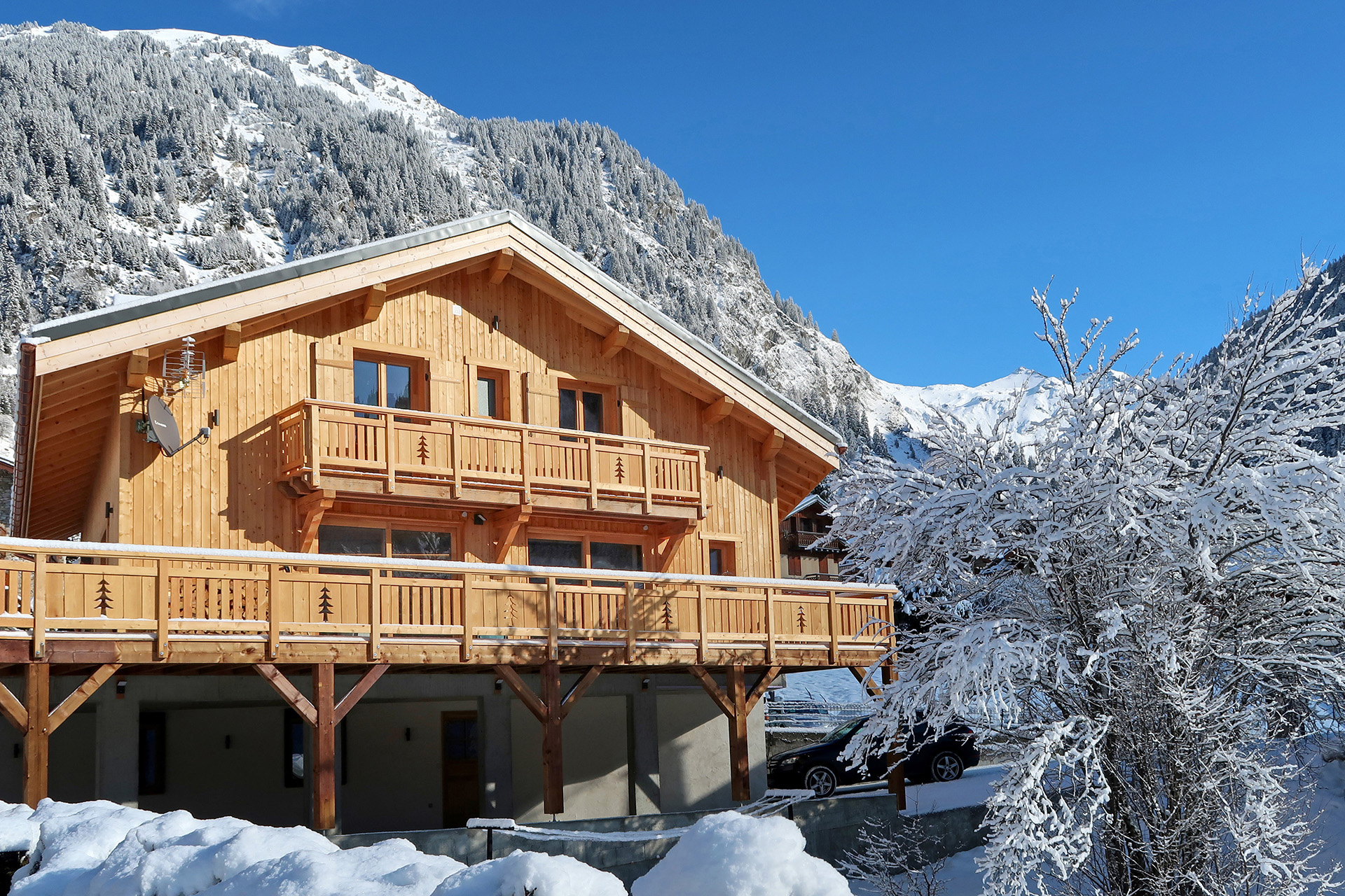 ferienhaus foto aussenaufnahme im winter mit blick auf schneeberge und blauer himmel