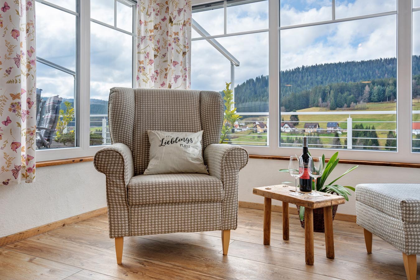 sessel vor Panoramafenster mit Kissen Lieblingsplatz