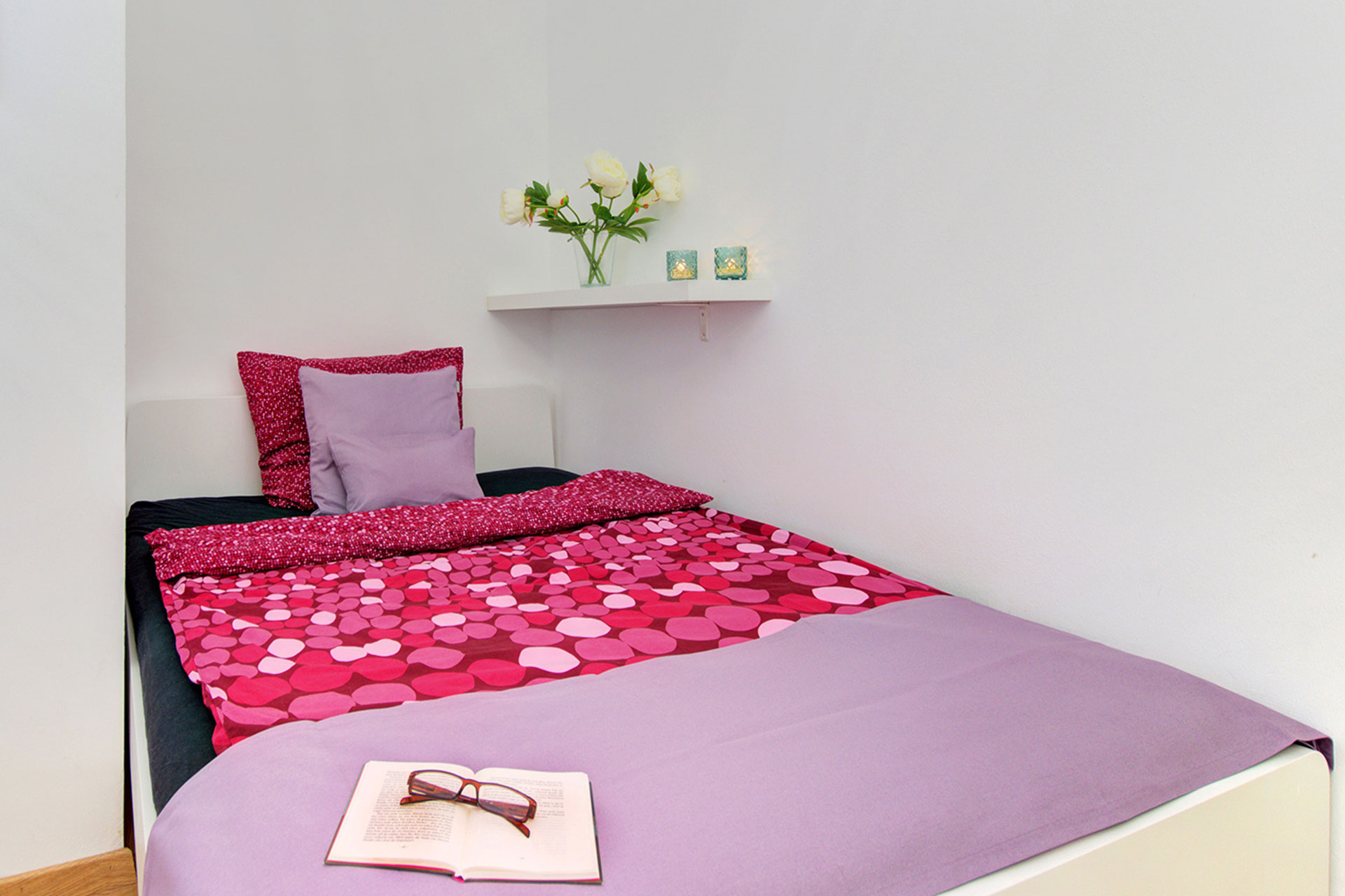 fotografin dekoriert einzelbett in lila mit bettläufer und kleinem kissen in fliederfarbe