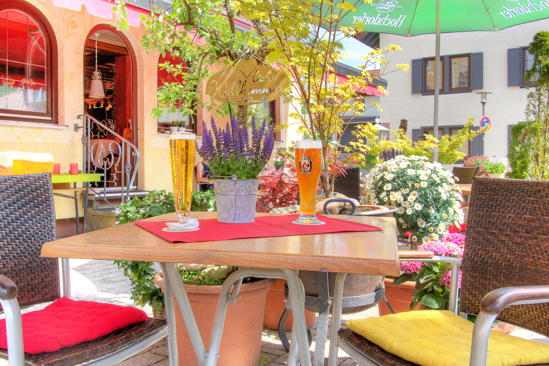 hotelfoto biergarten mit weiterem blick auf tisch mit zwei frisch gezapten bieren sowie lavendeltoepfchen