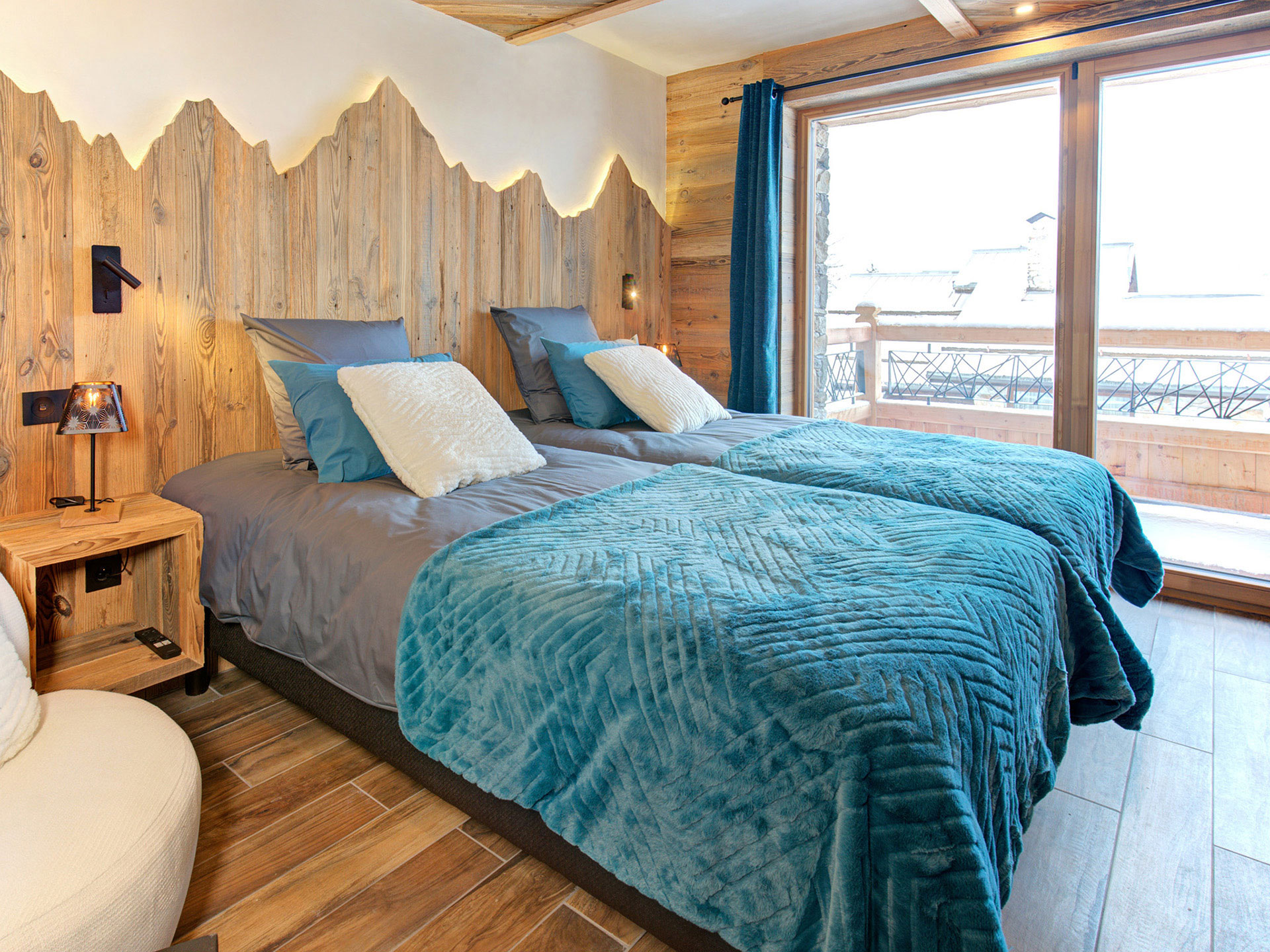 Schafzimmer mit Blick auf Panoramafenster und mit türkisfarbener Überdeck