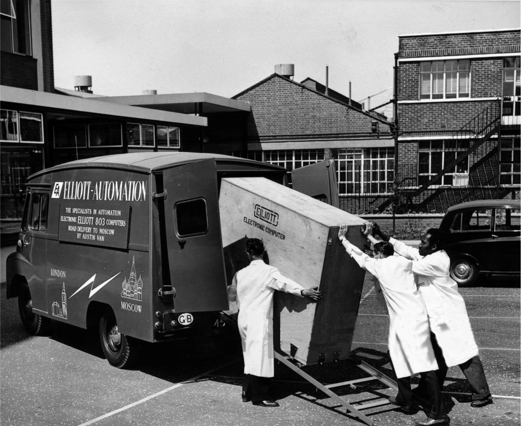 Caricamento di uno degli armadi che componevano un Elliott 803 in un apposito furgone, in uno dei cortili della fabbrica.