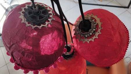 Lampions de couleurs faits en papier mâché. fixation et maintient de l'ampoule grâce à des pignons de vélo. 