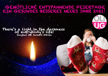 Kerze und Füße in Weihnachtssocken auf dem Tisch. Entspannte Feiertage