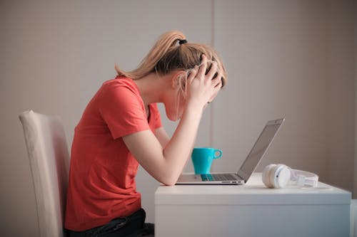 A female student holding her head in stress