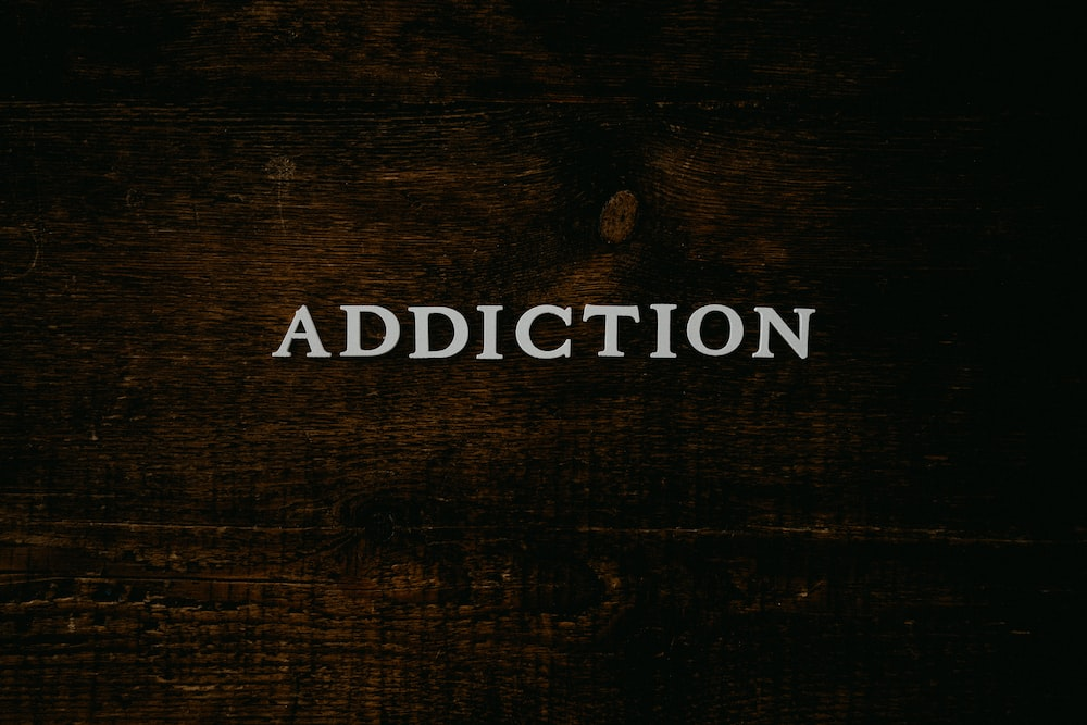 The word “addiction” on a wooden table