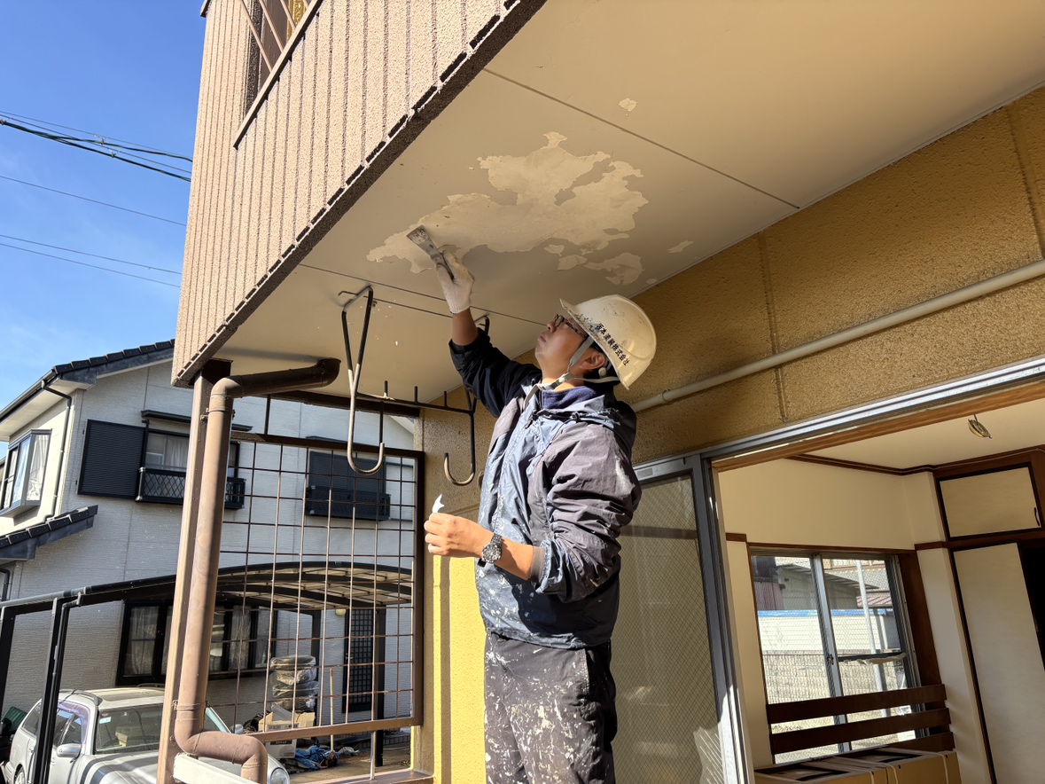 写真は、天井の塗膜（古い塗装面）が剥がれてしまった部分を、職人が丁寧に補修している様子です。 外壁や天井は、雨・湿気・温度変化の影響を受けやすく、年月が経つとどうしても塗装が浮いたり、剥がれたりすることがあります。  こうした状態のまま上から塗ってしまうと、すぐに再び剥がれてしまう原因になります。 そのため塗装の前には、写真のように 古い塗膜をしっかり削り落とす「下地調整」 が欠かせません。  この丁寧な下準備こそ、塗装を長持ちさせる一番のポイント。 坂本塗装では、見えない部分の作業も妥協せず、“仕上がりの美しさ”と“耐久性”の両方を大切にしています。  「天井の変色が気になる」「剥がれが出てきた」など、気になる症状があればお気軽にご相談ください。 小さなサインを見逃さず、建物を長く守るお手伝いをいたします。
