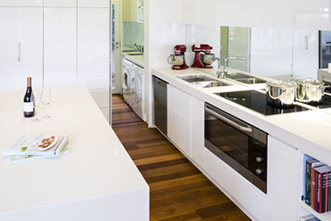 This stunning kitchen renovation features a sleek and modern design, complete with a beautiful stone benchtop crafted by Sydney Budget Kitchens.