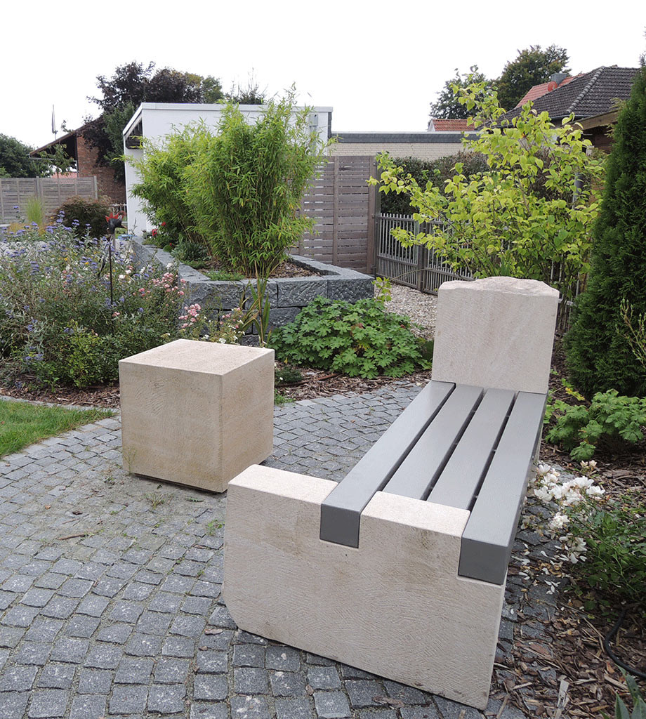 Gartenbank aus Thüster-Kalkstein und einem farbig lasiertem Leimbinder aus Douglasie.  Für die farbige Lasur sind div. Farbtöne möglich.  Gerne zeigen wir Ihnen Farbbeispiele. Die Sitzhölzer sind mit V2a Edelstahl zusammengefügt. 