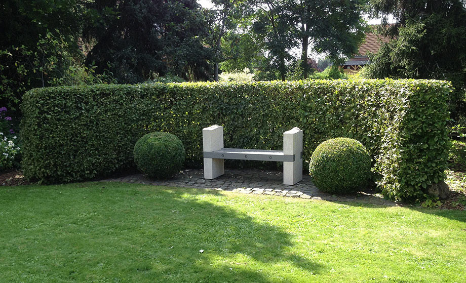 Gartenbank aus Thüster-Kalkstein und einem farbig lasiertem Leimbinder aus Douglasie.  Für die farbige Lasur sind div. Farbtöne möglich.  Gerne zeigen wir Ihnen Farbbeispiele. Die Sitzhölzer sind mit V2a Edelstahl zusammengefügt. 