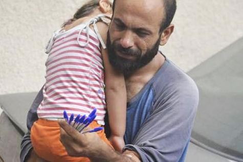 Eté 2015 : réfugié Syrien dans les rues de Beyrouth en train de vendre des stylos avec sa fille dans les bras