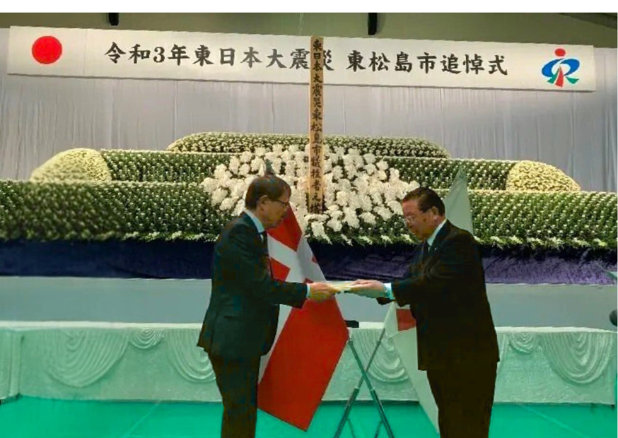 2021年3月11日東日本大震災犠牲者追悼式典で市長に本を手渡す佐野会長（東松島市）