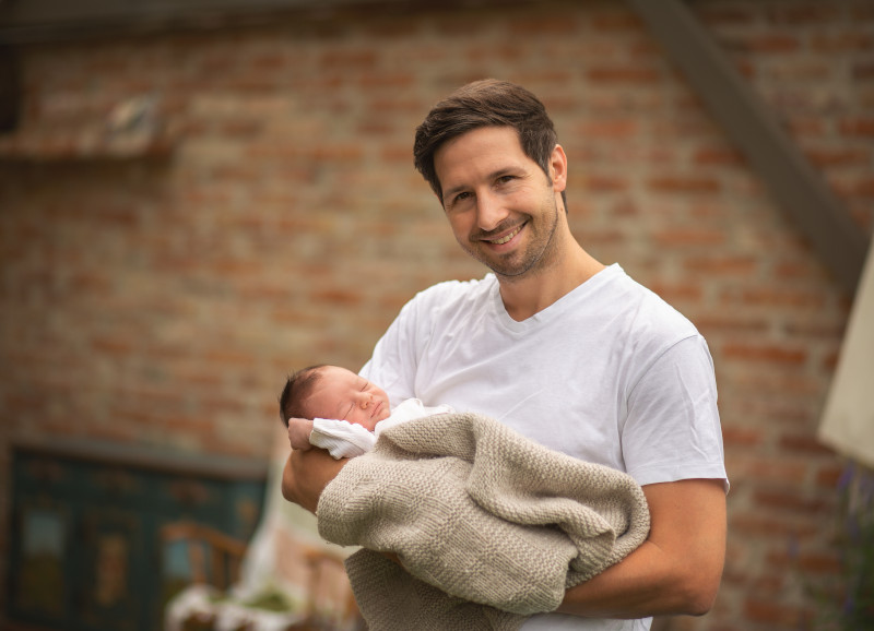 Papa mit Neugeborenem auf dem Arm in Erding