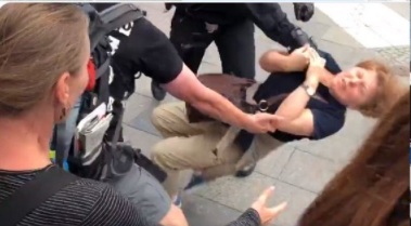 Screenshot 01.08.2021, Berlin: Querdenken-Demonstrantin wird von Polizei angegriffen, ein anderer Demoteilnehmer versucht zu helfen. Siehe Video unten, wie es dazu kam.. 