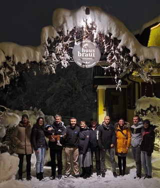 Das Team von Gerster Recycling steht auf einem Industriegelände. Im Hintergrund ist der Familienbetrieb und grosse rote Abfallcontainer mit dem Logo von Gerster Recycling zu sehen. Das Bild zeigt kompetente Fachpersonen.