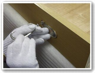 桐箪笥職人が引き出しの金具を付けている