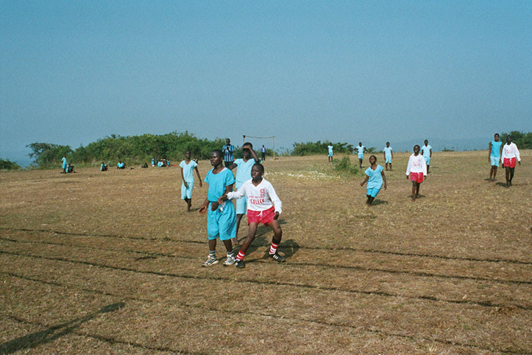 Kinder beim Austoben auf dem Sportplatz.