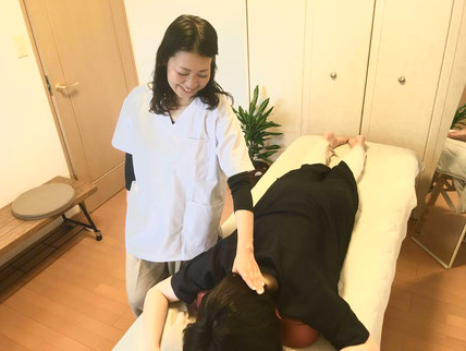 うつ伏せの患者さんに対し日だまりショットをしている時の写真