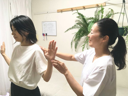 カエル体操を患者さんに指導する様子の画像